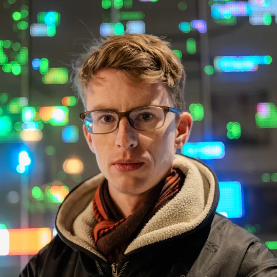 Lars at night in front of bokeh city lights